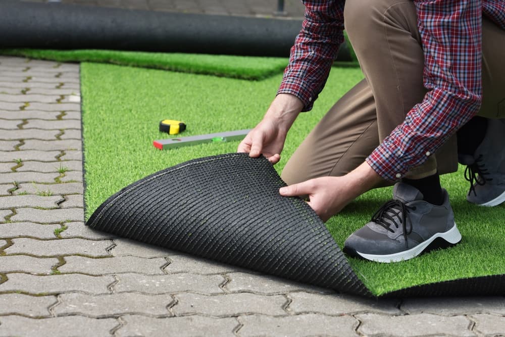 man installing artificial turf