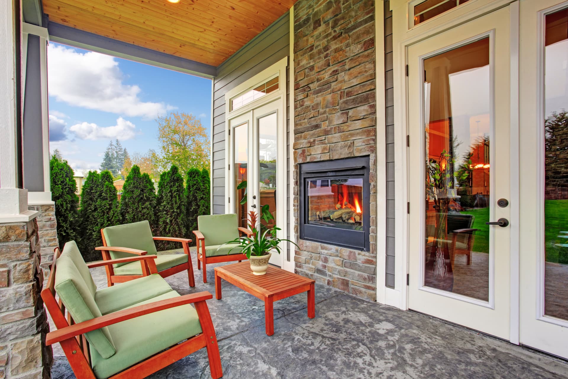 Cozy backyard deck with wooden furniture set and built in the wall fireplace